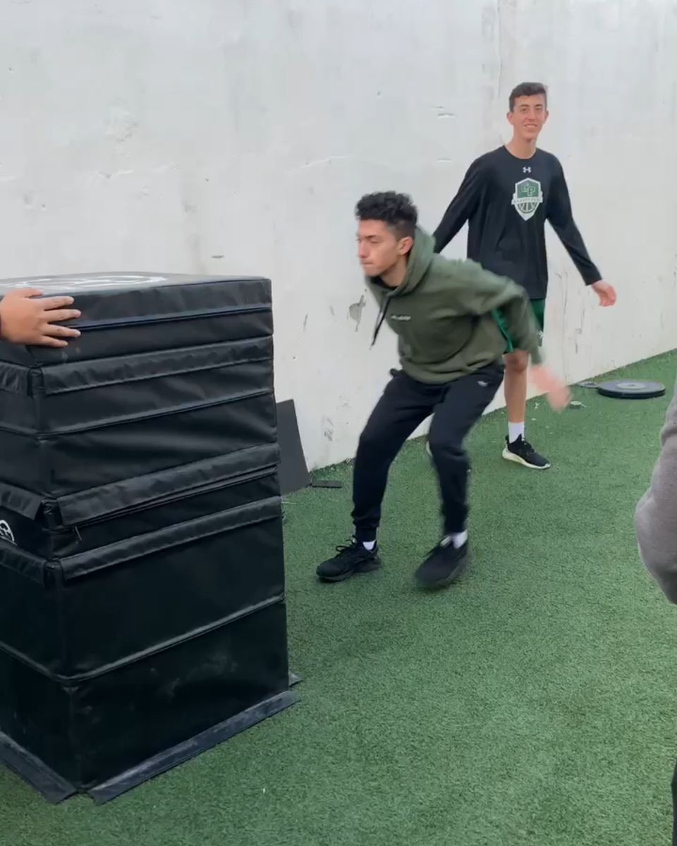 Athlete loading a box jump on the outdoor turf