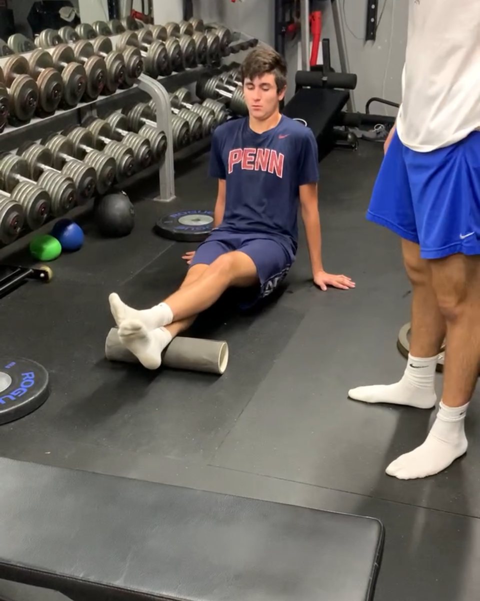 Athlete foam rolling his calves at Atlas Strength