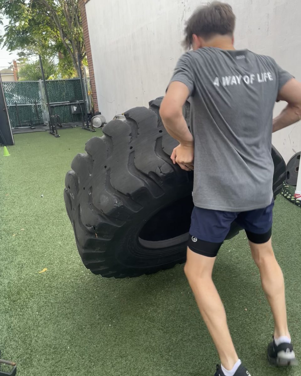 Athlete flipping a big tire on the outdoor turf