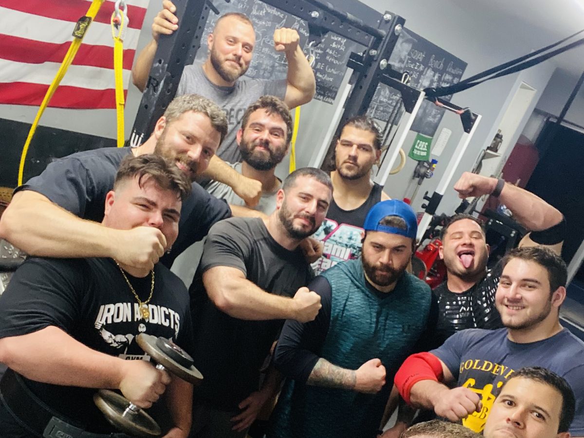 Group of lifters flexing together after training at Atlas Strength