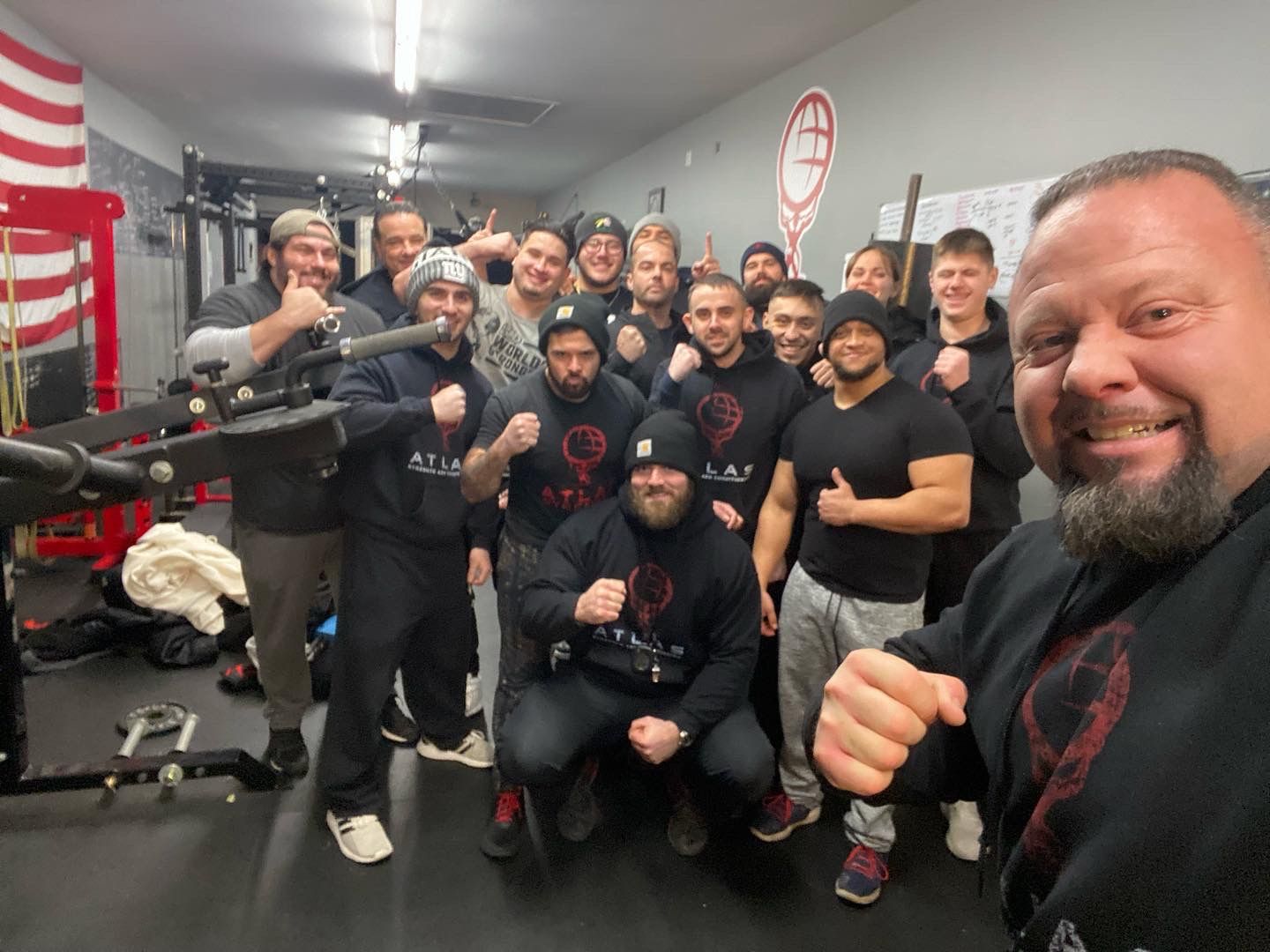 Atlas Strength members in Atlas gear posing together in the gym