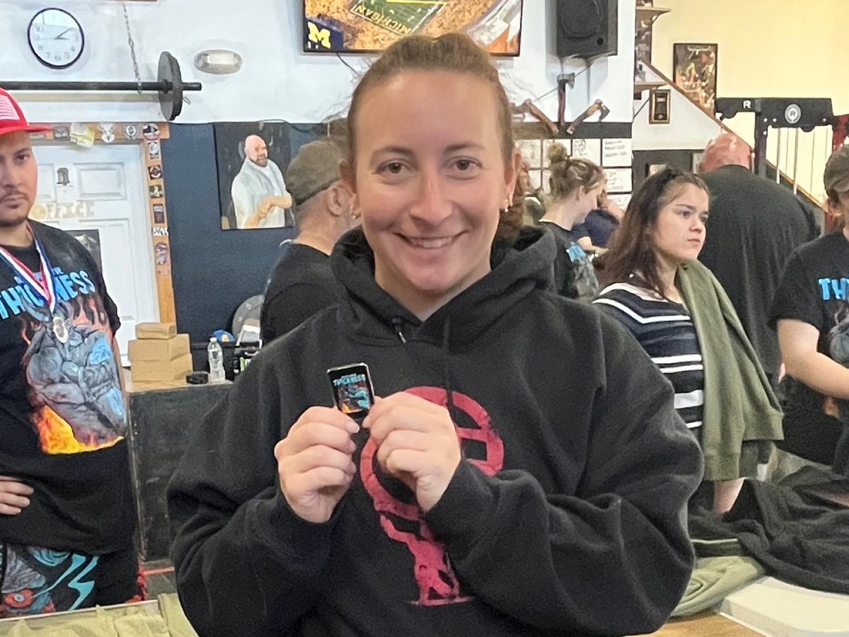 Atlas Strength member holding her award at a strongman competition