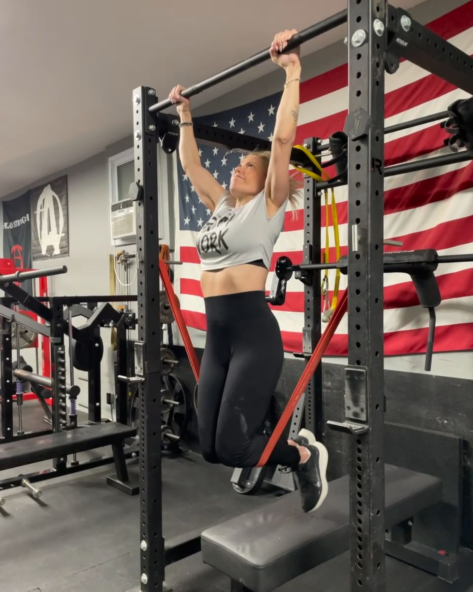 Client doing a band-assisted pull-up at Atlas Strength