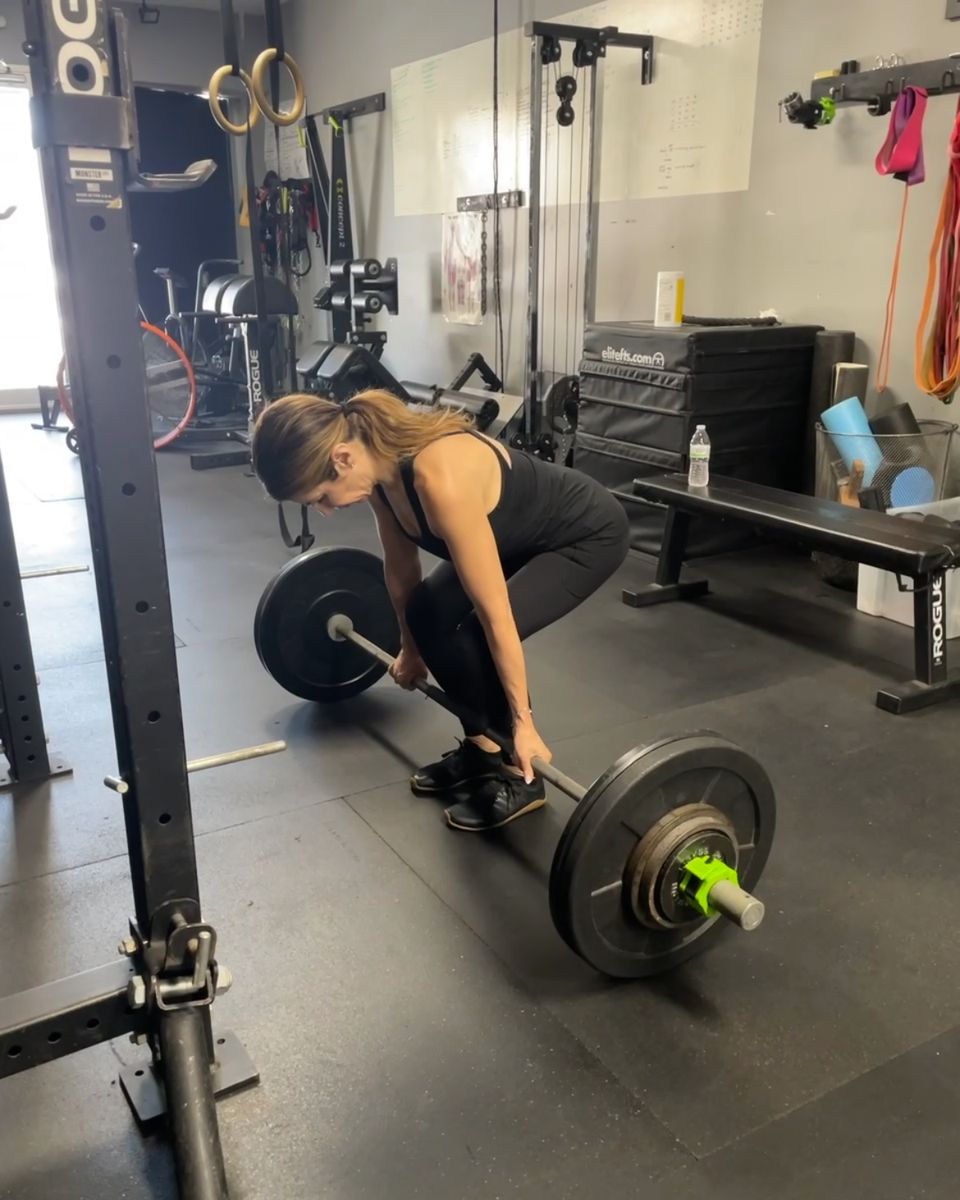 Client learning to deadlift with a light bar