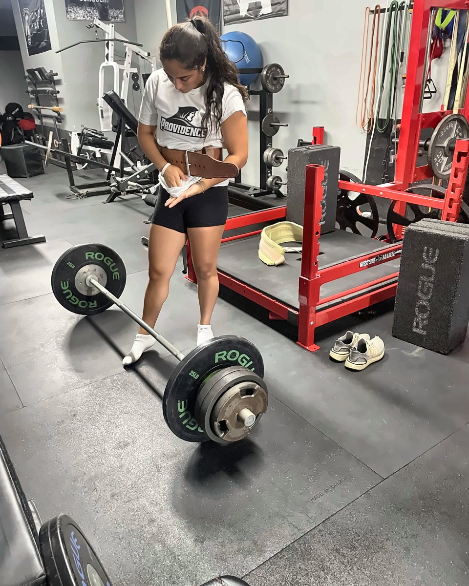College athlete belting up for a deadlift at Atlas Strength