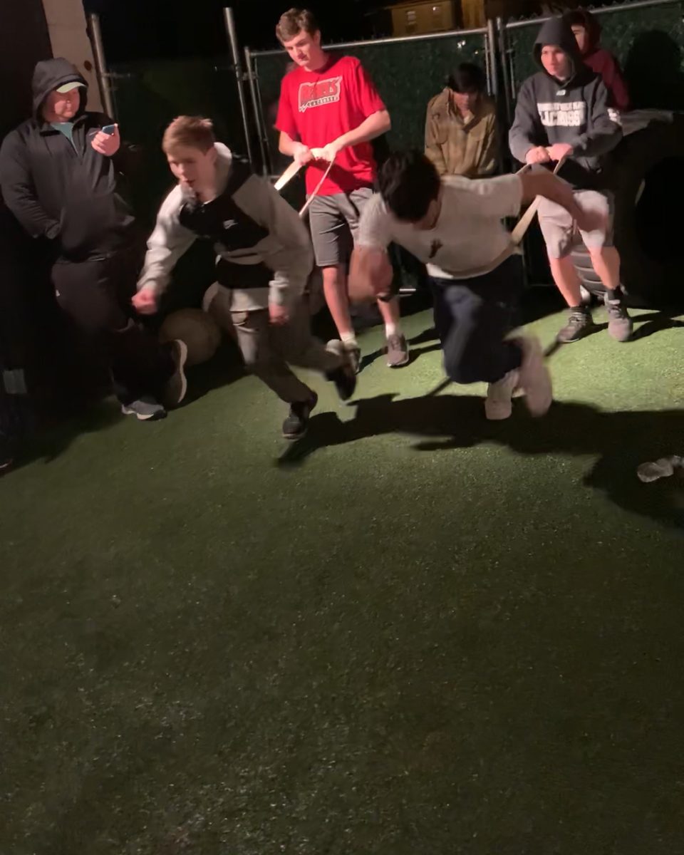 Players racing band-resisted sprint starts at night