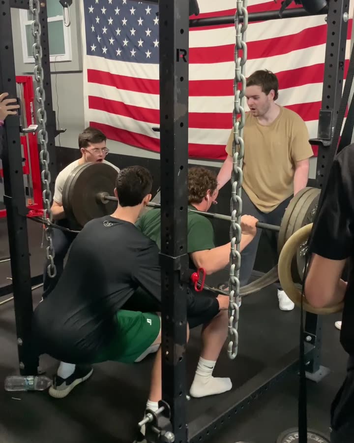 High school athletes squatting with chains