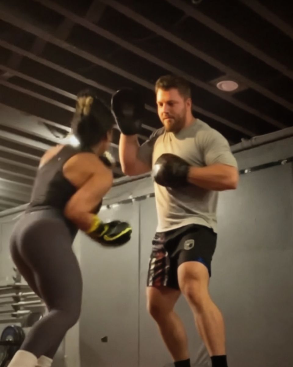 Patrick Rice holding pads for a client during a private kickboxing session