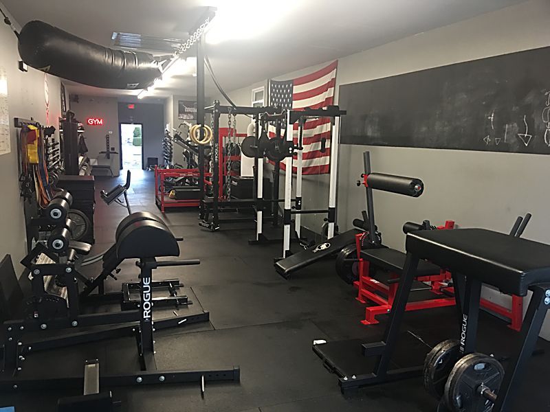 Main training floor with Rogue racks and specialty machines