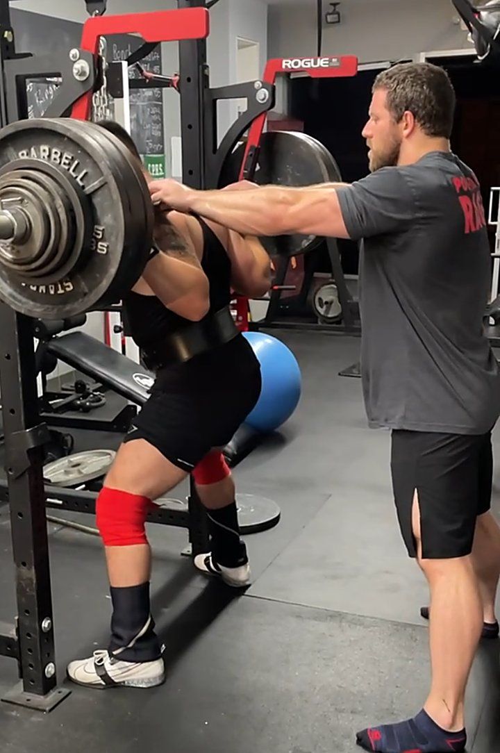 Patrick Rice coaching a client through a heavy squat