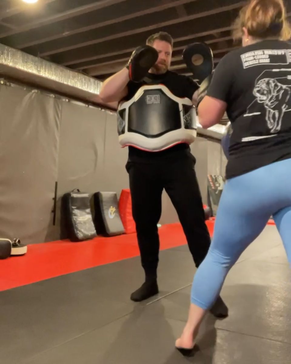 Patrick Rice holding pads with a belly protector for a client