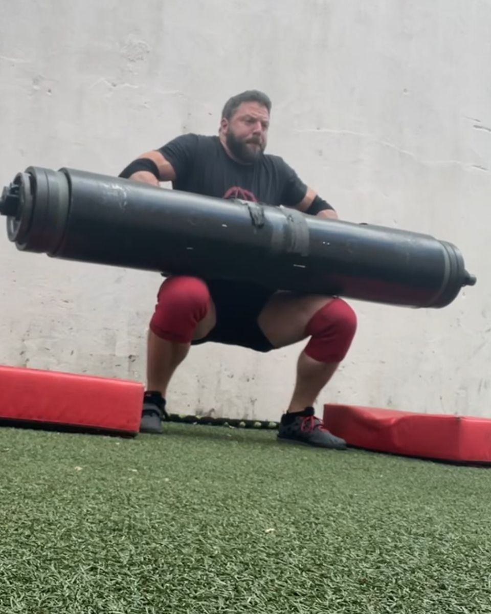 Patrick Rice lapping a strongman log on the turf