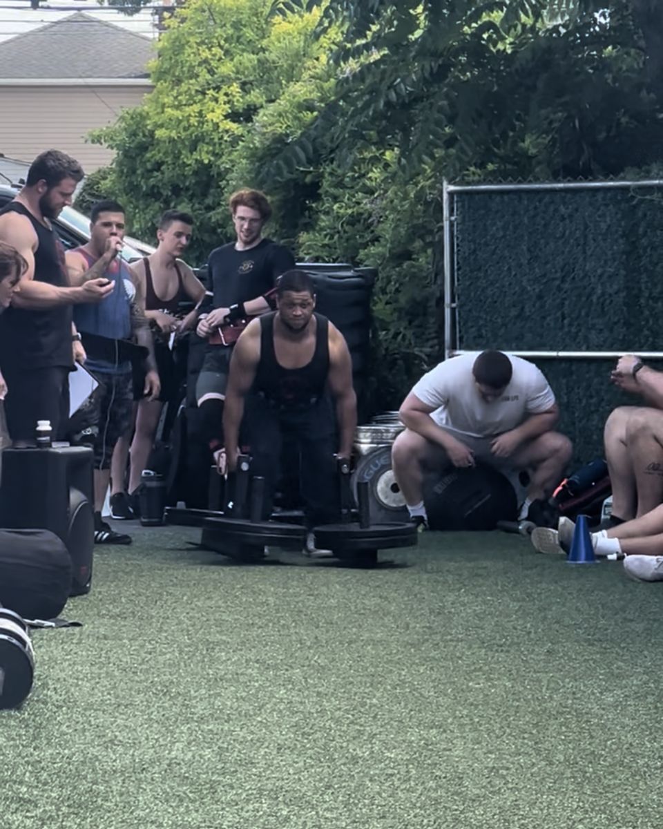 Strongman athletes cheering on a lifter at Atlas Strength