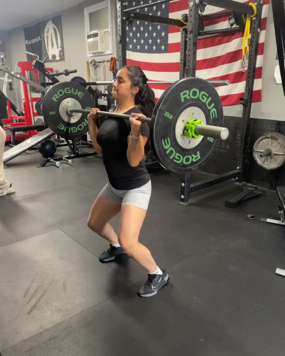 Young woman doing a barbell front rack lunge at Atlas Strength