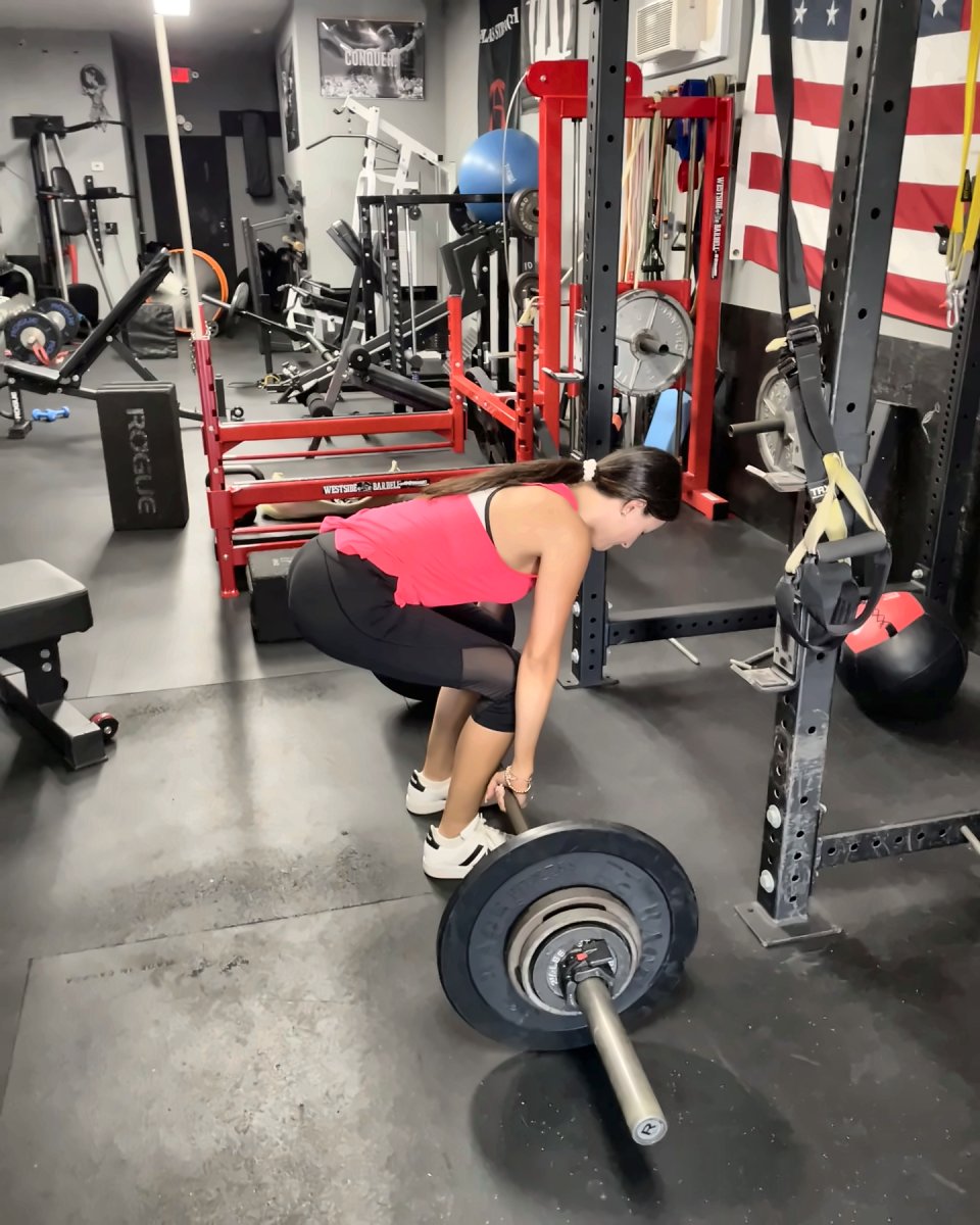 Woman setting up for a deadlift on the main floor at Atlas Strength