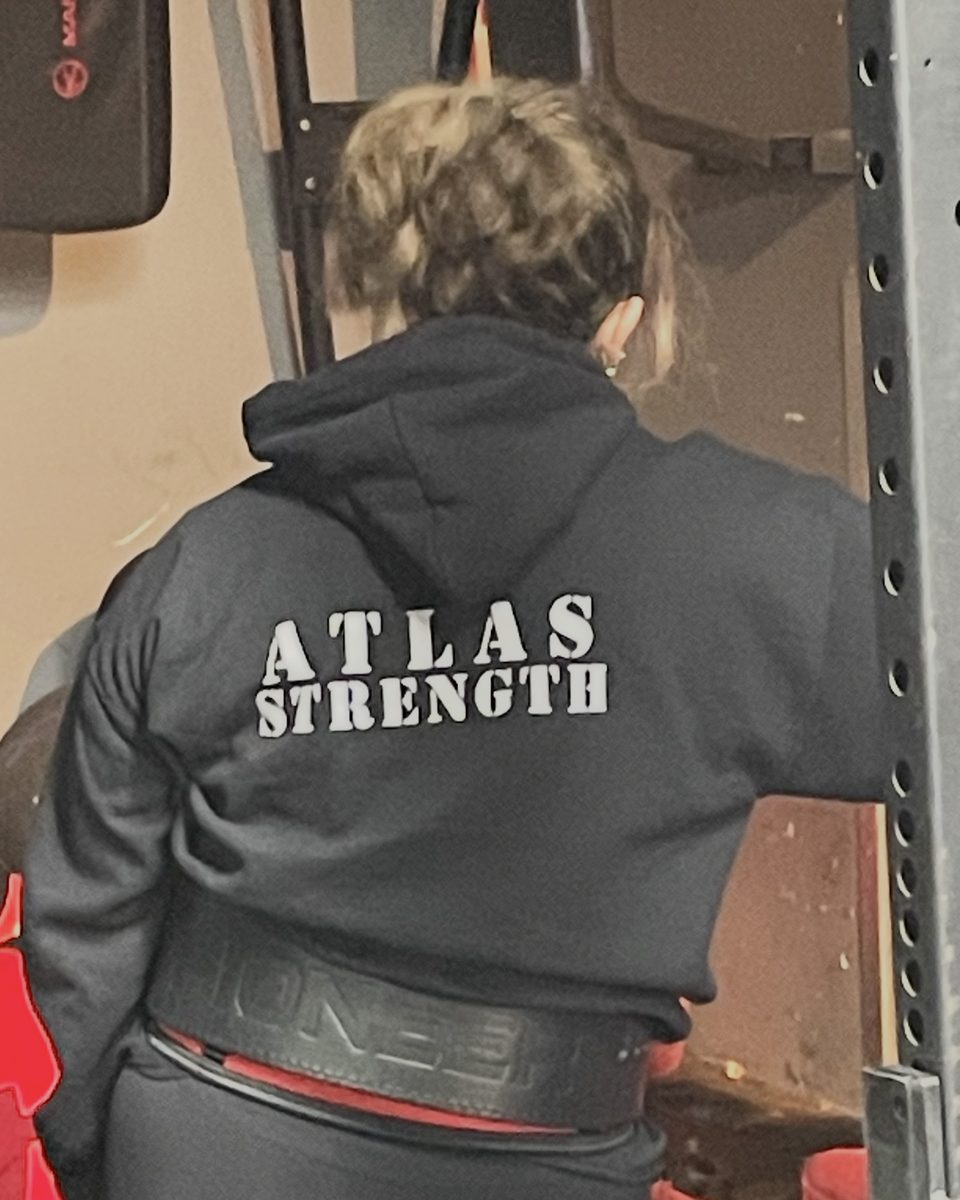 Woman in an Atlas Strength hoodie and lifting belt