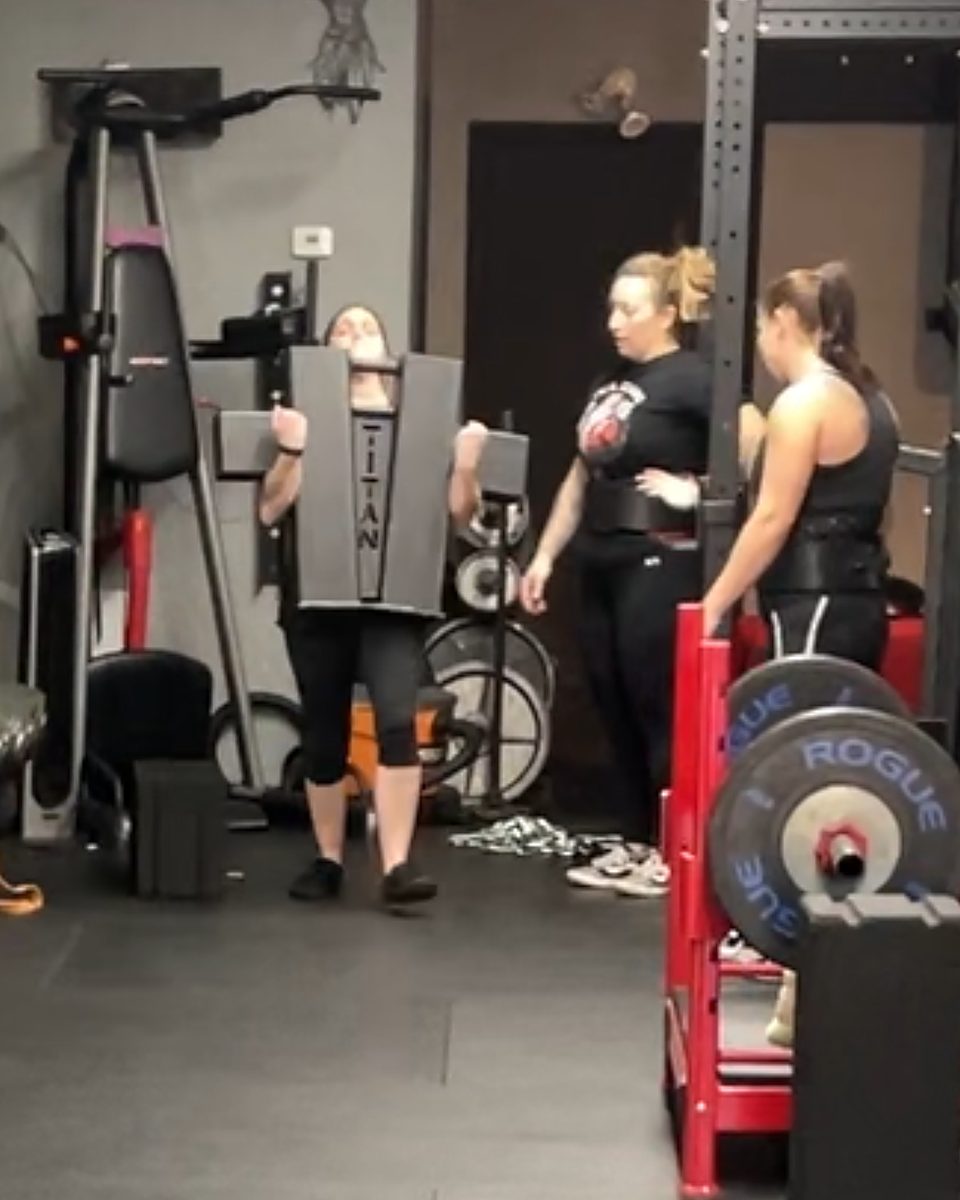 Woman doing a shield carry while two teammates watch